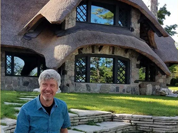 Seitz sitting in front of the Thatch House