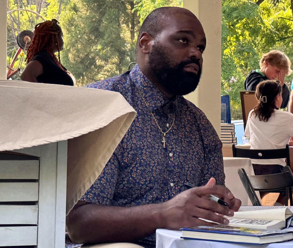 Former NFL football player Michael Oher, whose story became the inspiration for the Oscar-nominated movie “The Blind Side,” signs books at an event for his new memoir at a store in Baltimore, Monday, Aug. 21, 2023.