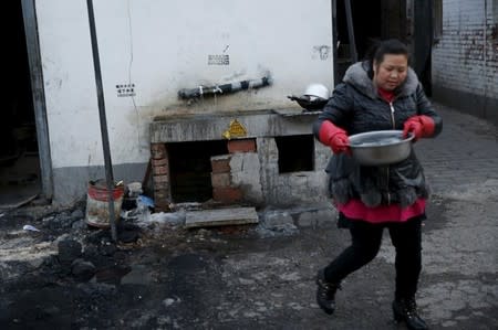 A migrant worker carries water for drinking and cooking from a public tap at a migrant workers' village in Beijing, China February 24, 2016. Residents use the tap water for drinking and washing. Some 650 million people, or one in 10 of the world's population, have no access to safe water, putting them at risk of infectious diseases and premature death. REUTERS/Kim Kyung-Hoon