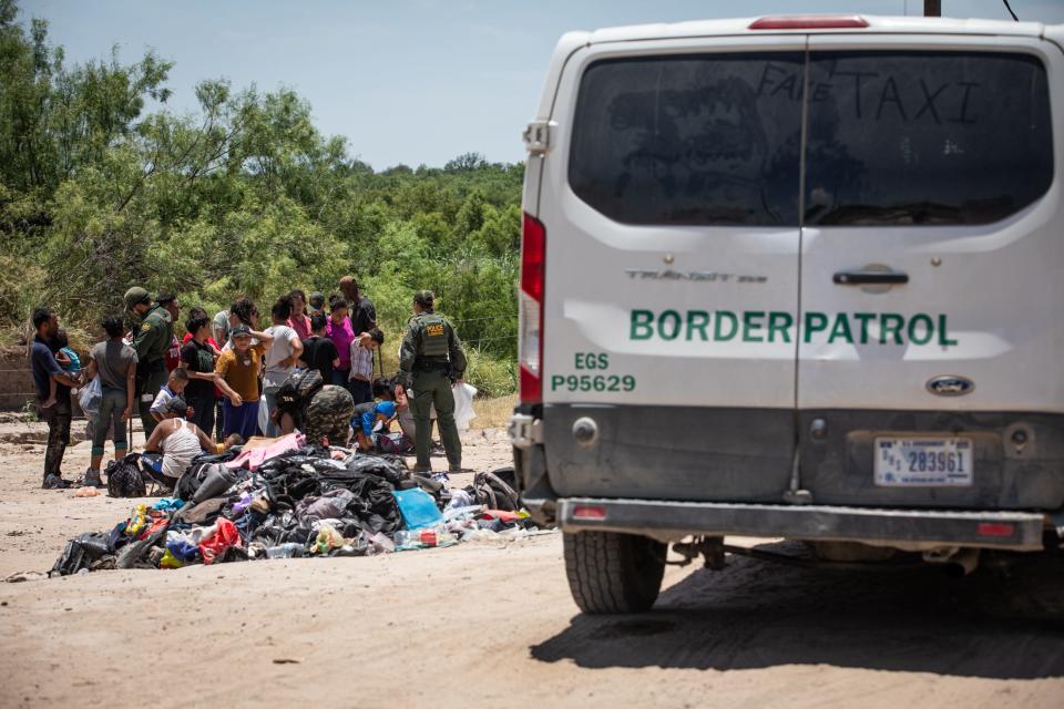 Migrants are taken into federal custody by Border Patrol agents about two miles east of where buoys were placed in the Rio Grande on Thursday, July 20, 2023, in Eagle Pass, Texas. 