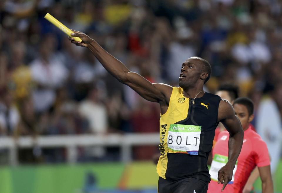 Usain Bolt points to the crowd after helping Jamaica win the men's 4x100 relay. (Reuters)