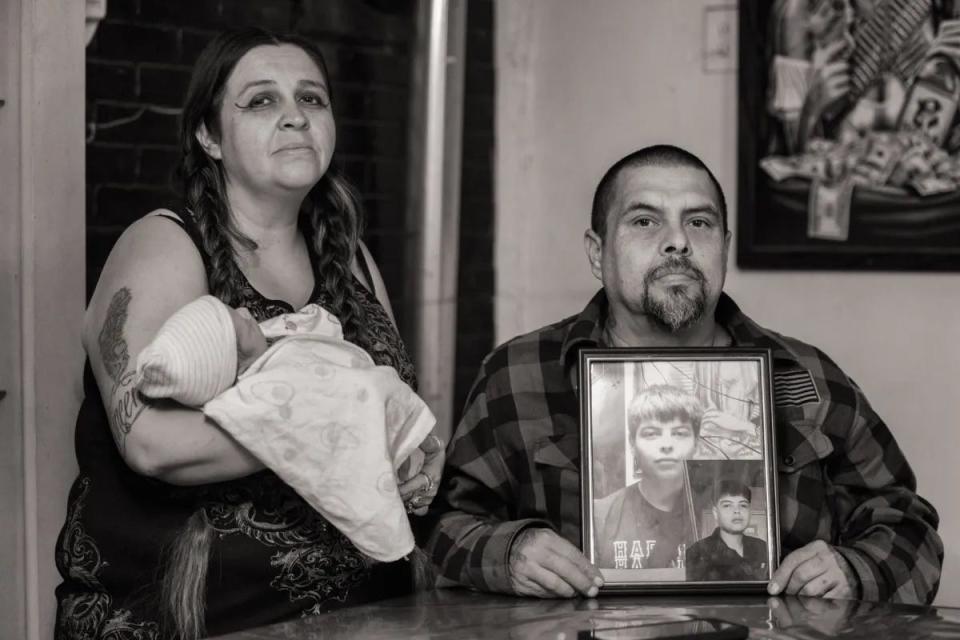 Kimberly Chavez holds her newborn as Vincent Chavez Sr. shows photos of their missing teenage son.