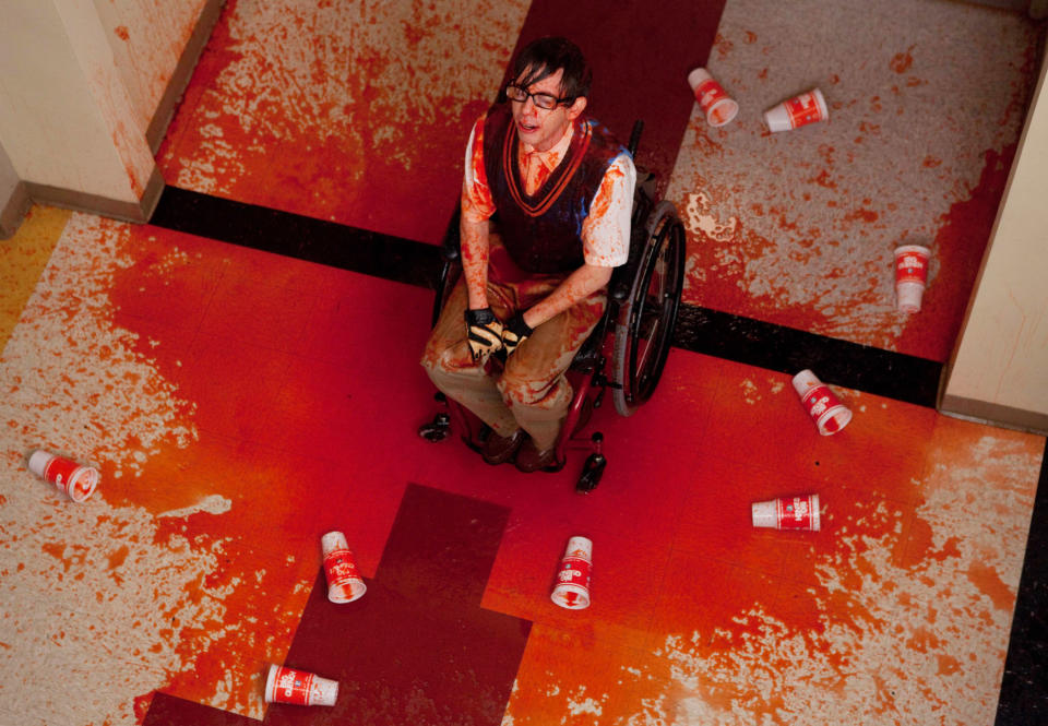 Kevin's character sitting in the middle of the hallway with slushie all over him and the floor, empty cups lying around