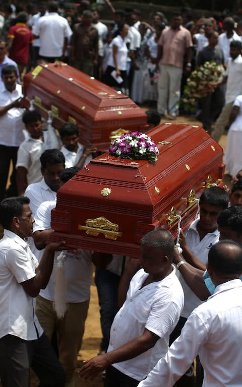 Mourners carry the coffins of victims during Tuesday's memorial ceremony - Credit: ATHIT PERAWONGMETHA/REUTERS