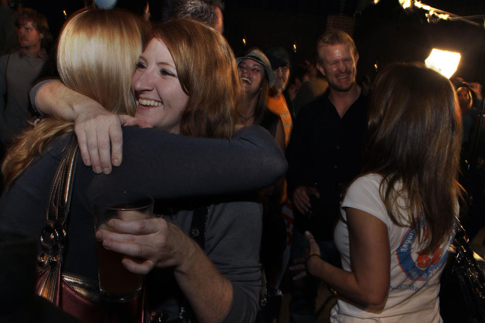 People attending an Amendment 64 watch party in a bar hug after a local television station announced the marijuana amendment's passage, in Denver, Colo., Tuesday, Nov. 6, 2012. The amendment would make it legal in Colorado for individuals to possess and for businesses to sell marijuana for recreational use. (AP Photo/Brennan Linsley)