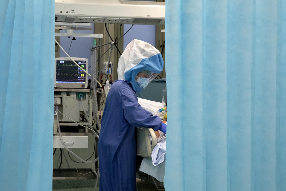 A nurse tends to a patient inside a COVID-19 intensive care unit of the Tor Vergata Polyclinic Hospital in Rome, Sunday, Dec. 13, 2020. Italy is reclaiming a record that nobody wants: The most coronavirus deaths in Europe. Italy is still trying to figure out how to protect its vulnerable elderly. (AP Photo/Alessandra Tarantino)