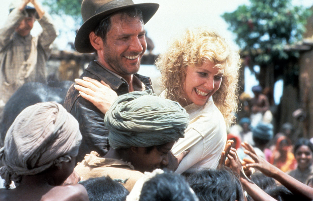 Harrison Ford and Kate Capshaw are greeted by children in a scene from the film 'Indiana Jones And The Temple Of Doom', 1984. (Photo by Paramount/Getty Images)