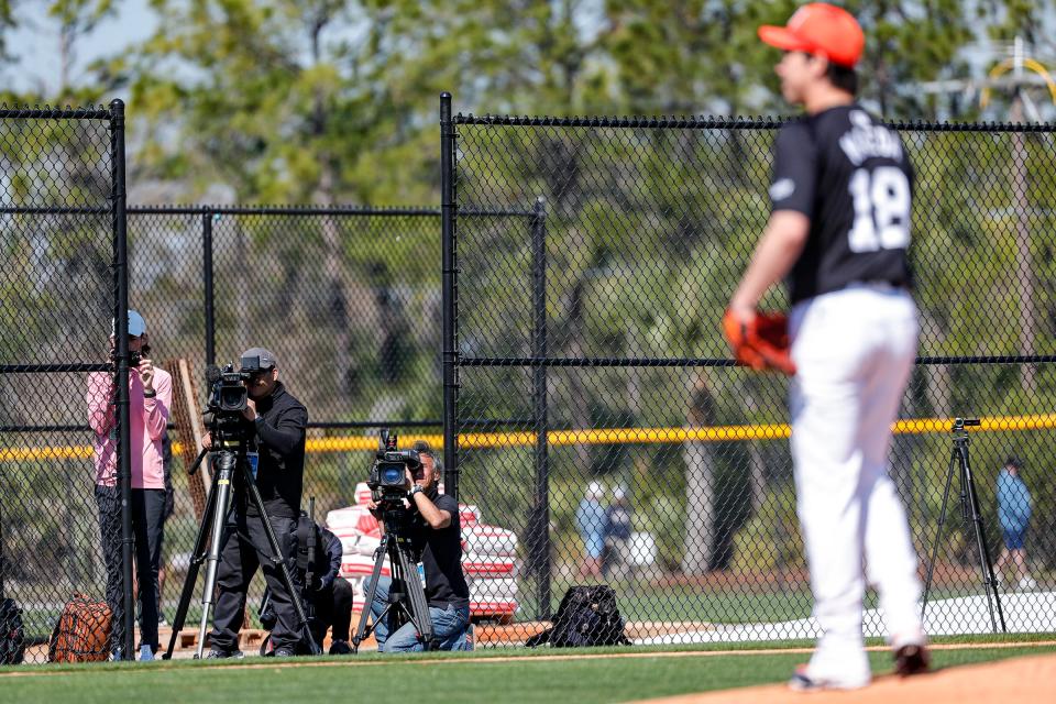 Media members record as pitcher Kenta Maeda throws a pitch during spring training at TigerTown in Lakeland, Fla. on Wednesday, Feb. 21, 2024.