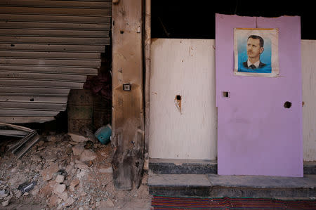 FILE PHOTO: A picture of Syrian President Bashar al-Assad is seen in Yarmouk Palestinian camp in Damascus, Syria October 10, 2018. Picture taken October 10, 2018. REUTERS/Omar Sanadiki/File Photo