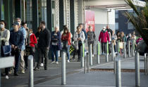 People queue early morning outside a supermarket in Hobsonville, Auckland, as New Zealand prepares to move into Covid-19 Alert Level 3, Wednesday, Aug. 12, 2020. New Zealand Prime Minister Jacinda Ardern said Tuesday, Aug. 11 authorities have found four cases of the coronavirus in one Auckland household from an unknown source, the first reported cases of local transmission in the country in 102 days. (Dean Purcell/New Zealand Herald via AP)