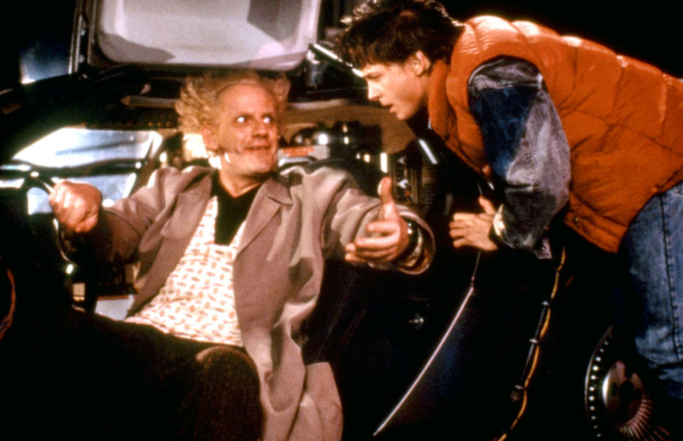 Dr Emmett Brown in the driver's seat and Marty McFly leaning over him