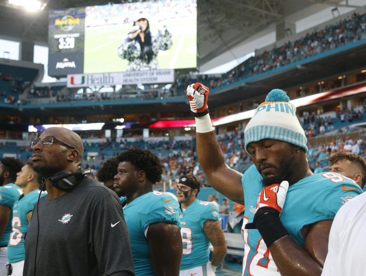 Dolphins defensive end Robert Quinn (94) raises his right fist during the singing of the national anthem on Thursday. (AP)