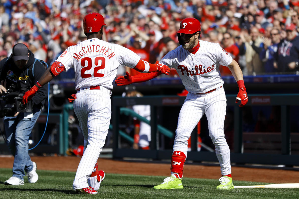 Philadelphia Phillies' Bryce Harper gives Andrew McCutchen a hat