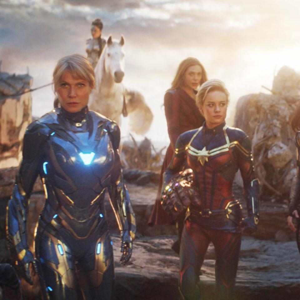 Female superheroes from a film stand ready for action, featuring characters like Captain Marvel and Black Widow