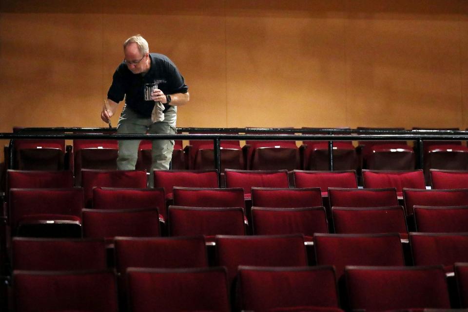 Joe Shannon, production manager at E.J. Thomas Hall, applies a fresh coat of paint to the handrails ahead of the venue's 50th season on Aug. 29 in Akron.