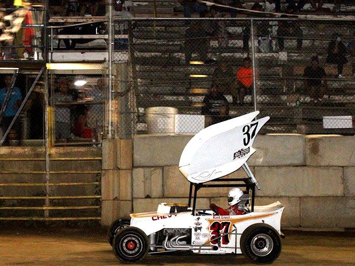 Legendary dirt track racer The Hurrying Hoosier Hank Lower takes the checkered flag during Old Timer’s Night Saturday