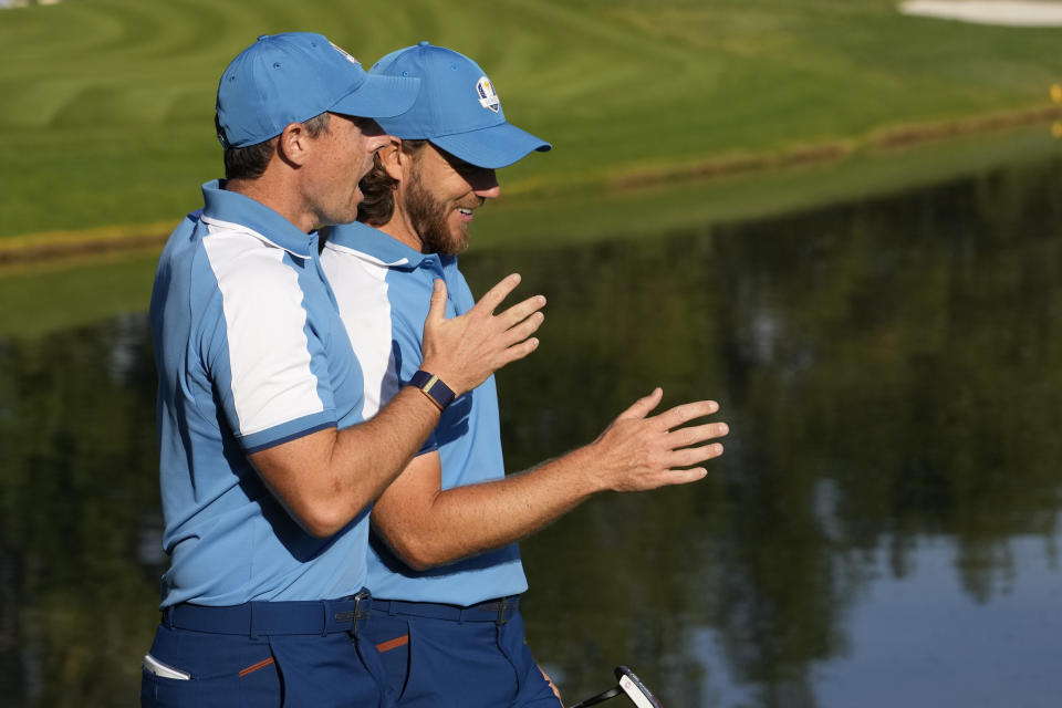 Europe's Rory Mcilroy, left and playing partner Europe's Tommy Fleetwood react as they walk on the 5th green during their morning Foursome match at the Ryder Cup golf tournament at the Marco Simone Golf Club in Guidonia Montecelio, Italy, Friday, Sept. 29, 2023. (AP Photo/Andrew Medichini)