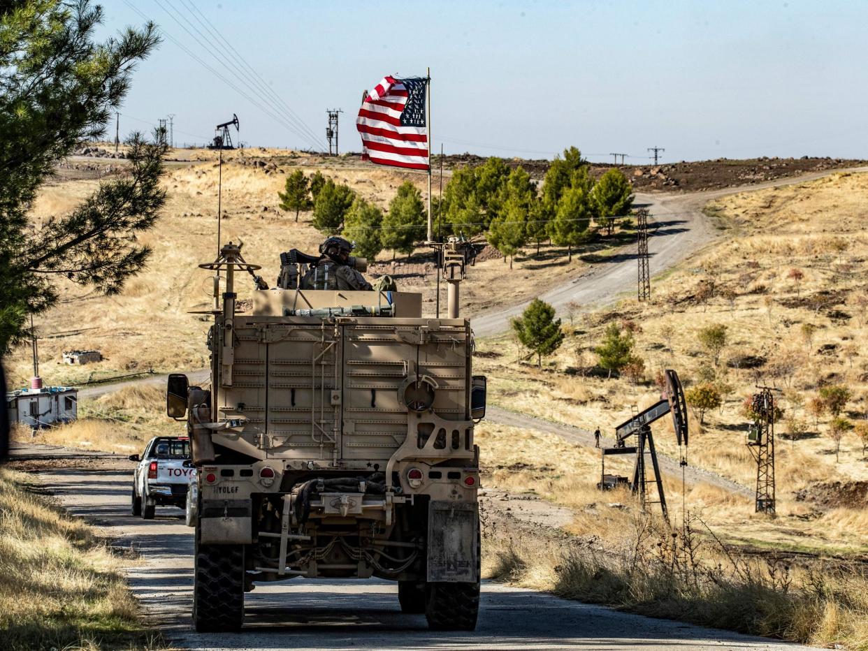 American soldiers drive past an oil well in Syria: Getty