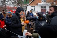 People, including supporters of Alexei Navalny, gather outside a police station where the opposition leader is being held following his detention, in Khimki