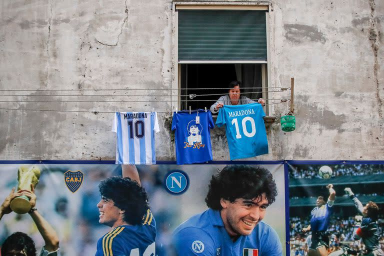 Una mujer cuelga camisteas de Maradona en el popular barrio "Quartieri Spagnoli", en Nápoles