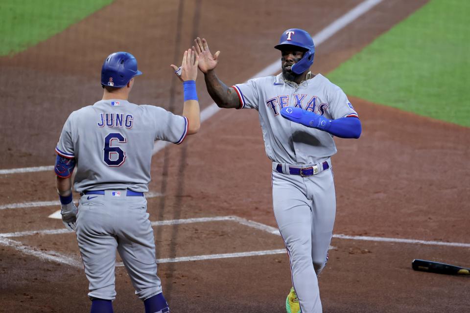 Adolis Garcia celebrates with Josh Jung after scoring a run in the first inning.