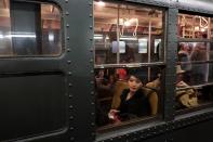 NEW YORK, NY - DECEMBER 16: A woman dressed in period costume sits in a vintage New York City subway on December 16, 2012 in New York City. The New York Metropolitan Transportation Authority (MTA) runs vintage subway trains from the 1930's-1970's each Sunday along the M train route from Manhattan to Queens through the first of the year. (Photo by Preston Rescigno/Getty Images)