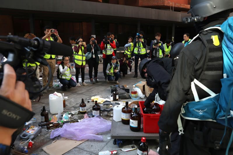 Members of a safety team established by police and local authorities assess and clear unsafe items, next to the media, at the Hong Kong Polytechnic University (PolyU) in Hong Kong, China