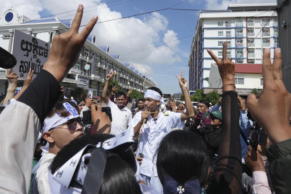 An environmental activist, center, raises a V-sign together with supporters as he leads a protest near Phnom Penh Municipality Court, in Phnom Penh, Cambodia, Tuesday, July 2, 2024. Ten members of a nonviolent environmental activist group in Cambodia were convicted on Tuesday on charges of conspiracy to commit a crime, receiving prison sentences of six years each. (AP Photo/Heng Sinith)