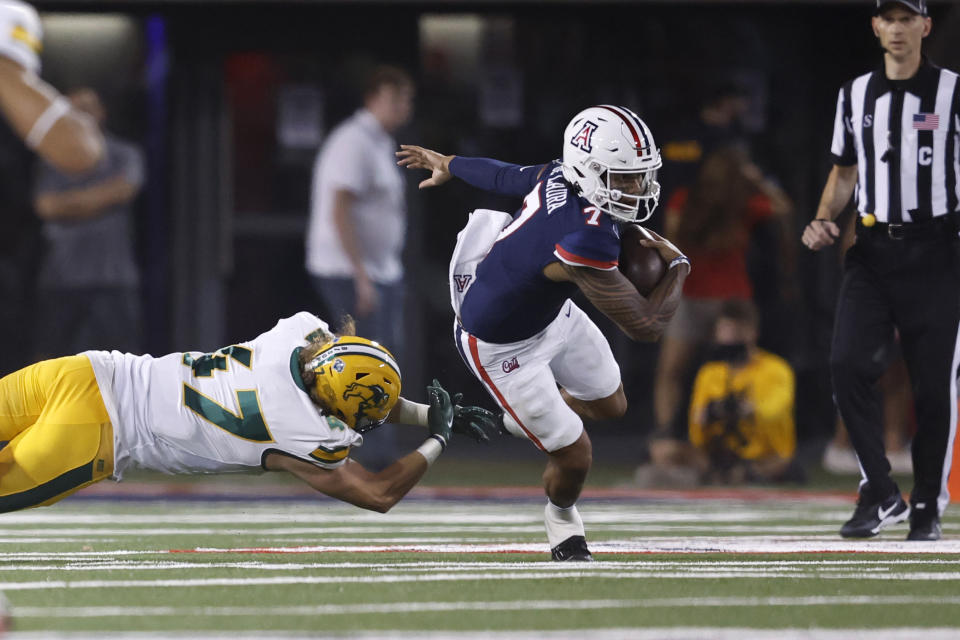 Arizona quarterback Jayden de Laura (7) runs past North Dakota State linebacker Luke Weerts during the first half of an NCAA college football game Saturday, Sept. 17, 2022, in Tucson, Ariz. (AP Photo/Chris Coduto)