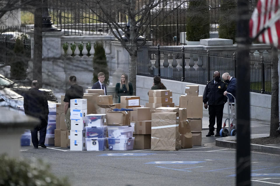 FILE - In this Jan. 14, 2021, file photo people wait for a moving van after boxes were moved out of the Eisenhower Executive Office building inside the White House complex in Washington. The public won’t see President Donald Trump’s White House records for years, but there’s growing concern that they won’t be complete, leaving a hole in the history of one of America’s most tumultuous presidencies. (AP Photo/Gerald Herbert, File)