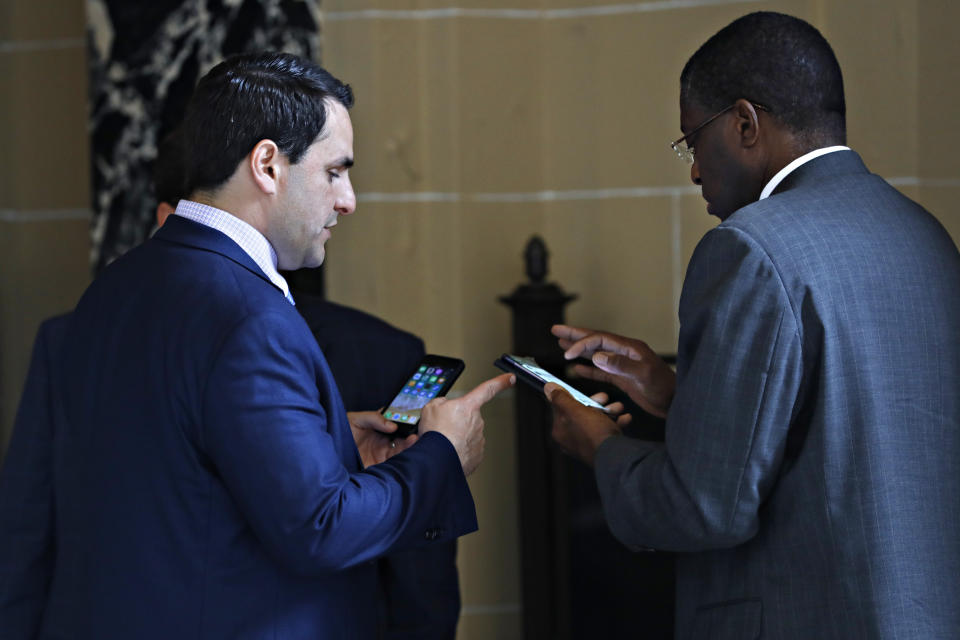 U.S. Permanent Representative to the Organization of American States Carlos Trujillo, left, confers with Jamaican Alternate Representative to the OAS Deon Williams minutes before the OAS Permanent Council holds an extraordinary session on Venezuela at the headquarters of the organization in Washington on Tuesday, April 9, 2019. (AP Photo/Jacquelyn Martin)