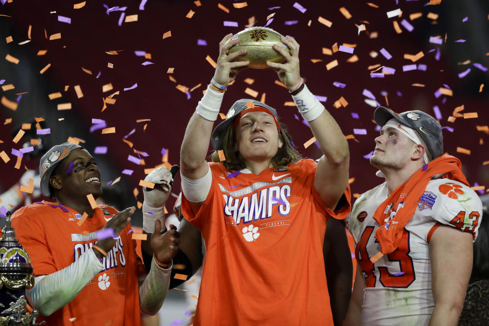 Clemson quarterback Trevor Lawrence holds the trophy after Clemson defeated Ohio State 29-23 in the Fiesta Bowl NCAA college football playoff semifinal Saturday, Dec. 28, 2019, in Glendale, Ariz. (AP Photo/Rick Scuteri)