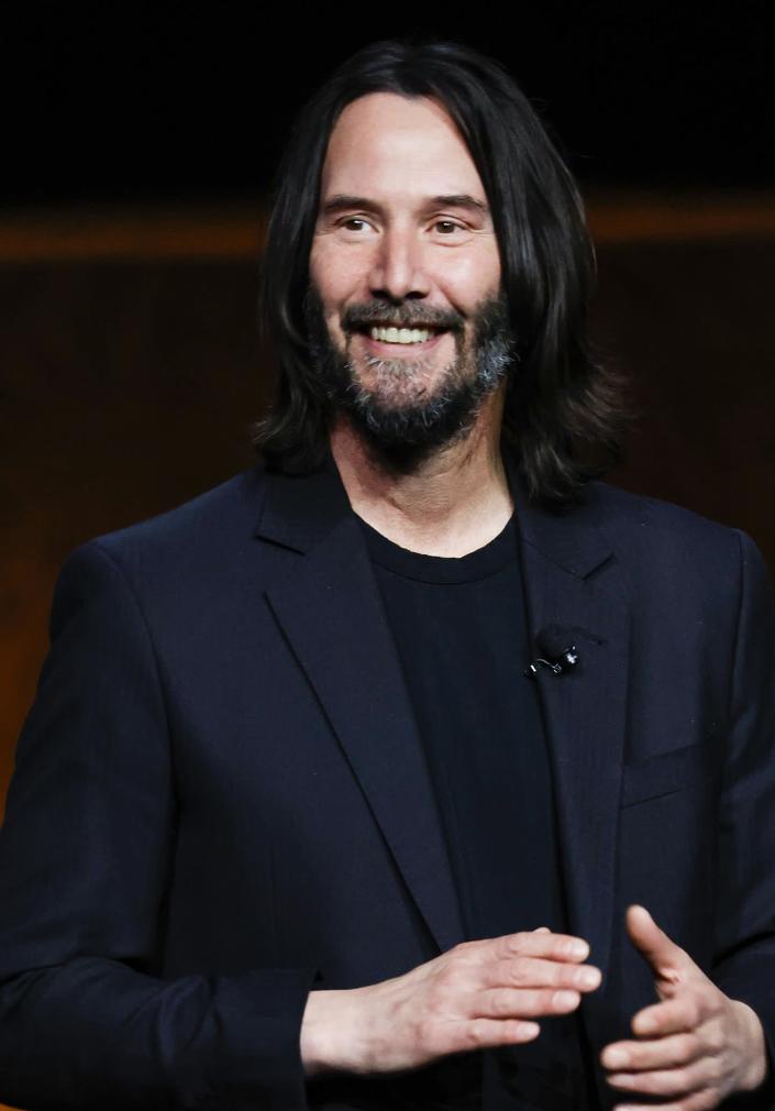 Keanu Reeves smiling and clapping