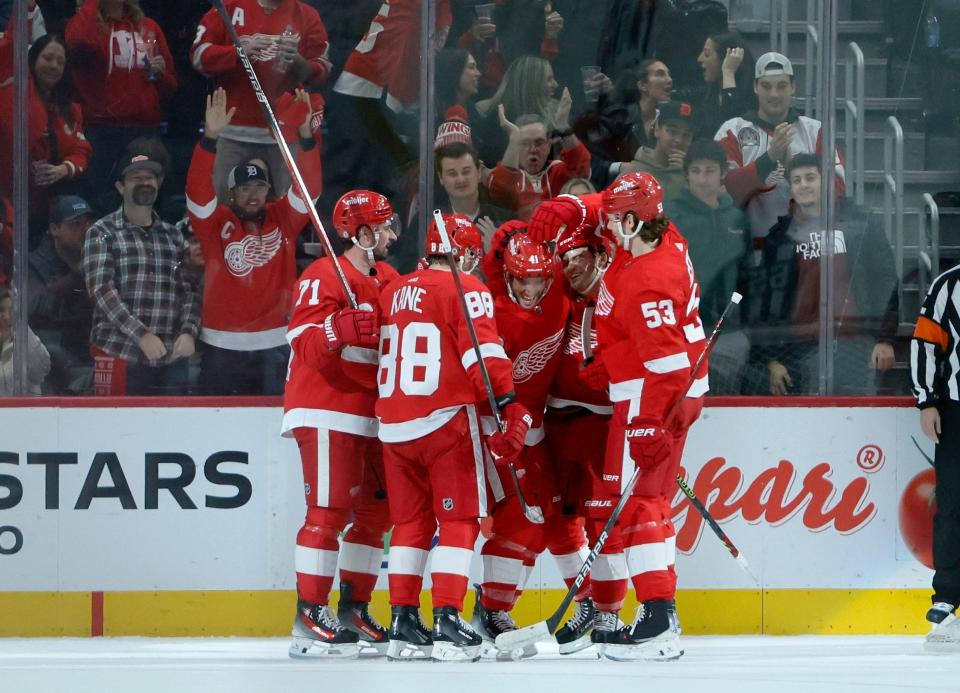 Detroit Red Wings defenseman Shayne Gostisbehere (41) celebrates with center Dylan Larkin (71), right wing Patrick Kane (88), right wing Alex DeBrincat (93) and defenseman Moritz Seider (53) after scoring against the Philadelphia Flyers during the first period at Little Caesars Arena in Detroit on Friday, Dec. 22, 2023.