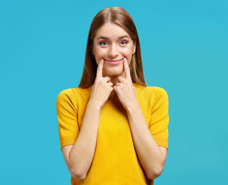 Mujer con sonrisa falsa.