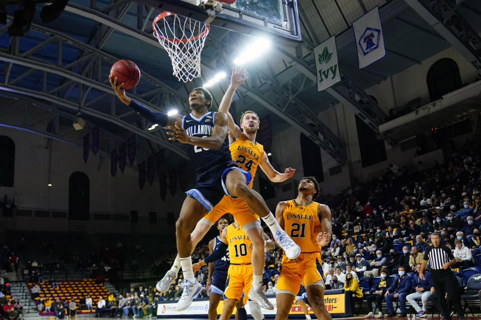 Villanova's Jermaine Samuels, left, goes up for a shot againstLa Salle's Christian Ray during the first half of an NCAA college basketball game, Sunday, Nov. 28, 2021, in Philadelphia. (AP Photo/Matt Slocum)