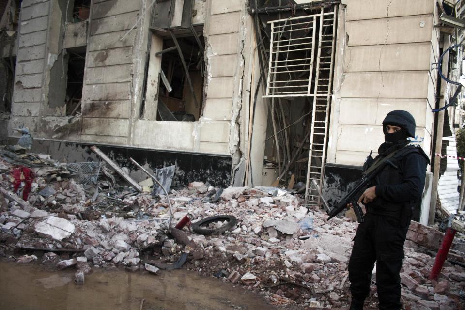 FILE - In this file photo taken Tuesday, Dec. 24, 2013, an Egyptian policeman guards the scene of an explosion at a police headquarters building that killed at least a dozen people, wounded more than 100, and left scores buried under the rubble, in the Nile Delta city of Mansoura, 110 kilometers (70 miles) north of Cairo, Egypt. The militant group Ansar Beit al-Maqdis, which has waged a campaign of bombings and assassinations for months in Egypt, has quickly advanced in weaponry and sophistication of attacks, drawing on the experience of Egyptians who fought in Syria. (AP Photo/Ahmed Ashraf, File)