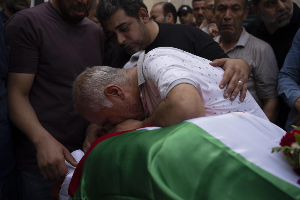 Palestinians mourns over the body of the doctor Ossayed Kamal Jabareen, at the government hospital in the West Bank city of Jenin, Thursday, May 23, 2024. The Israeli military said Thursday it has completed a two-day operation in the occupied West Bank that the Palestinian Health Ministry says killed 12 Palestinians. Militant groups claimed at least eight of the dead as fighters, one from Hamas and seven from the Al-Aqsa Martyrs Brigade. (AP Photo/Leo Correa)