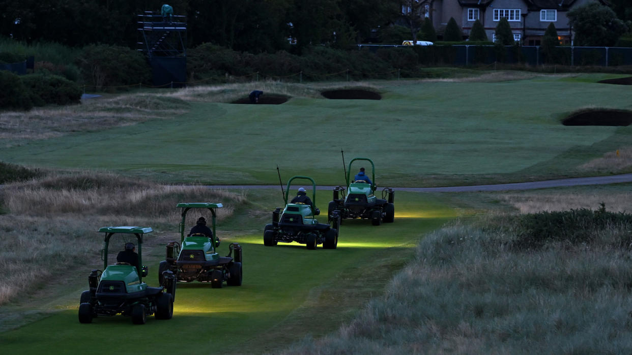  Greenkeepers on mowers before sunrise at Royal Liverpool Golf Club 