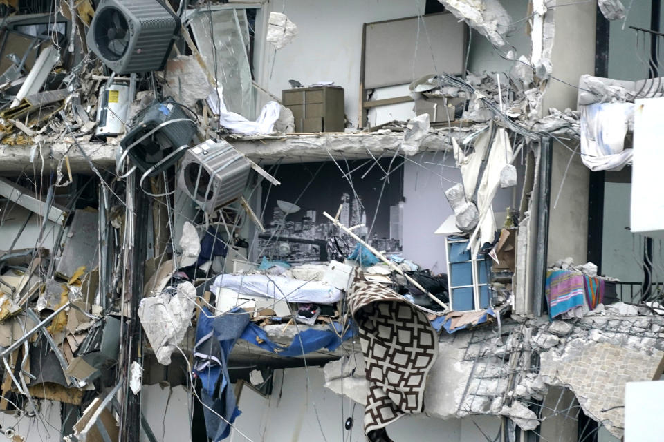 Household items and debris dangle from a partially collapsed multistory beachfront condo, Thursday, June 24, 2021, in Surfside, Fla. (AP Photo/Wilfredo Lee)