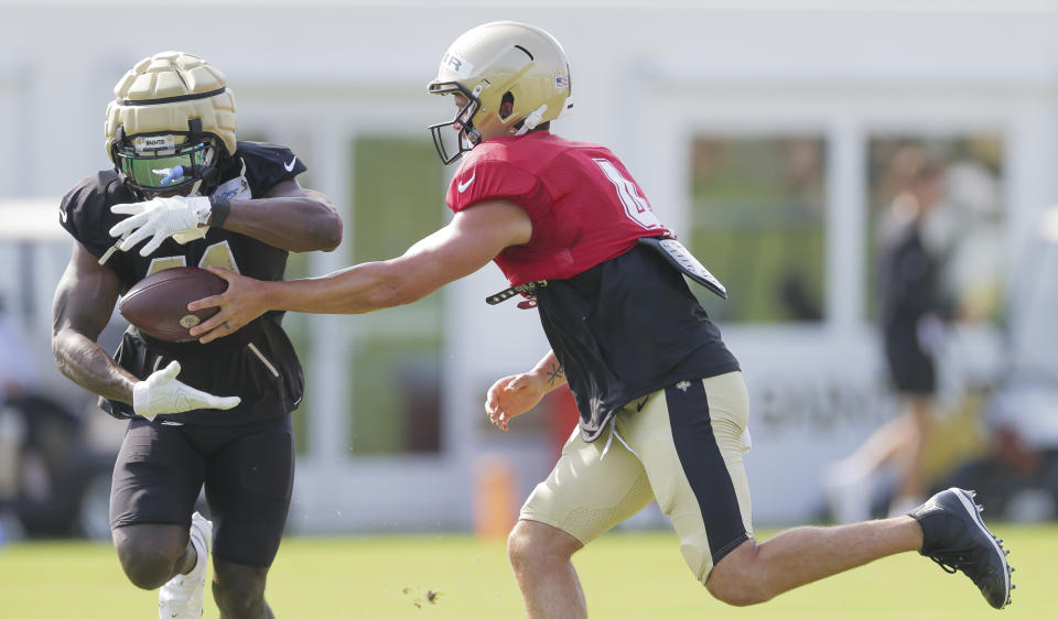 New Orleans Saints quarterback Derek Carr (4) hands the ball to Saints running back Alvin Kamara (41) during a drill at NFL football training camp practice in Metairie, La., Monday, July 31, 2023. (David Grunfeld/The New Orleans Advocate via AP)