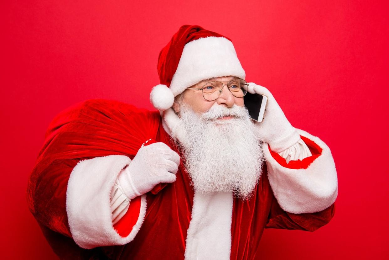 Santa Claus Talking on Phone Holding Bag of Presents Red