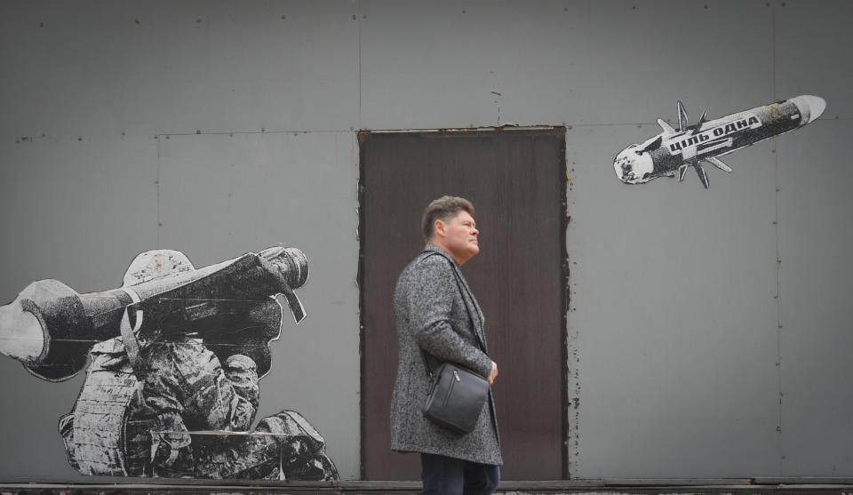 A man passes by graffiti depicting a Ukrainian soldier firing an anti-tank missile in Kyiv, Ukraine, Monday, Oct. 24, 2022. Writing on the missile reads: "The goal is one." Eight months ago, on Feb. 24, Russia launched an invasion of Ukraine. (AP Photo/Efrem Lukatsky)