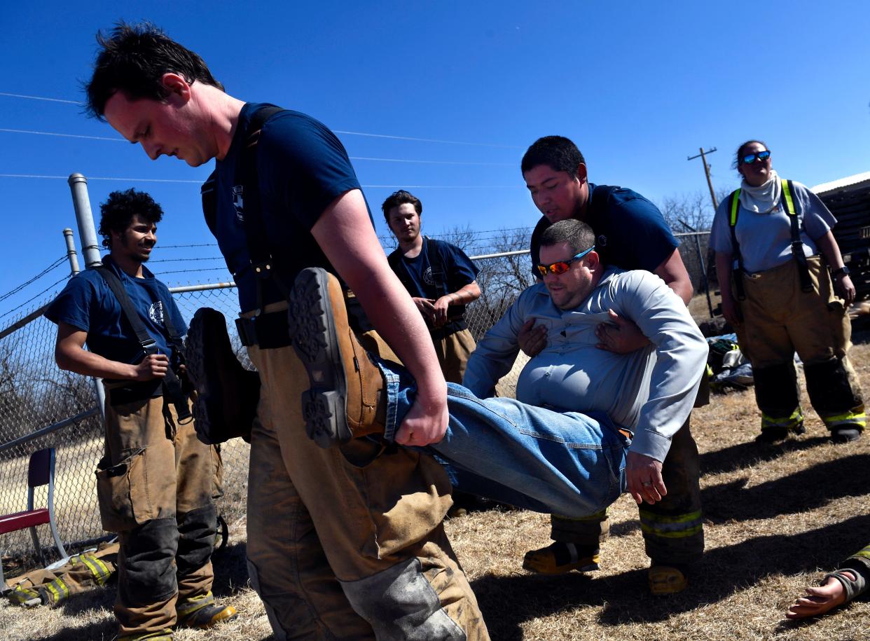 Eula firefighters Abner Hill (left) and Daniel Mendez carry Brent Speck, assistant chief for the Hawley Volunteer Fire Department, as part of an exercise Saturday.