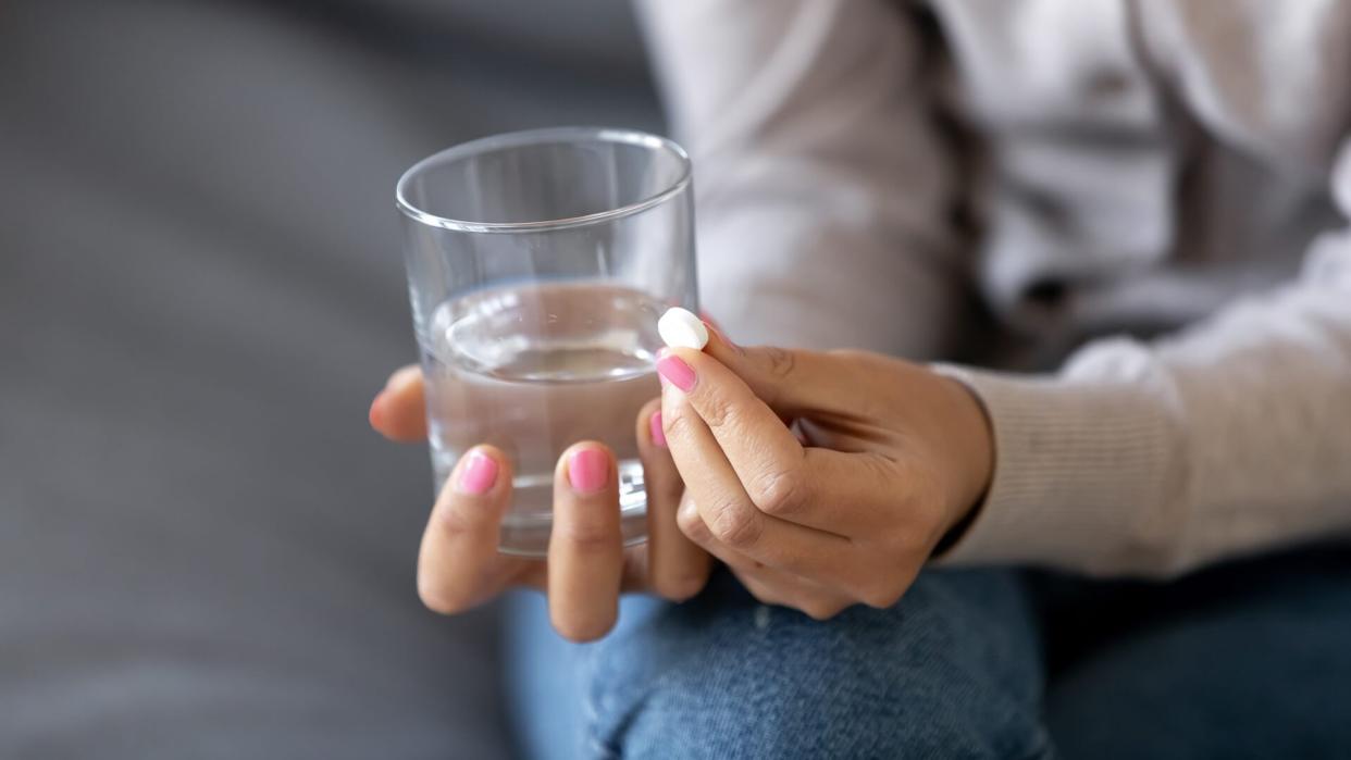 woman taking an aspirin pill