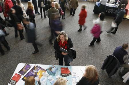 A job seeker (C) talks to an exhibitor at the Colorado Hospital Association health care career fair in Denver April 9, 2013. REUTERS/Rick Wilking