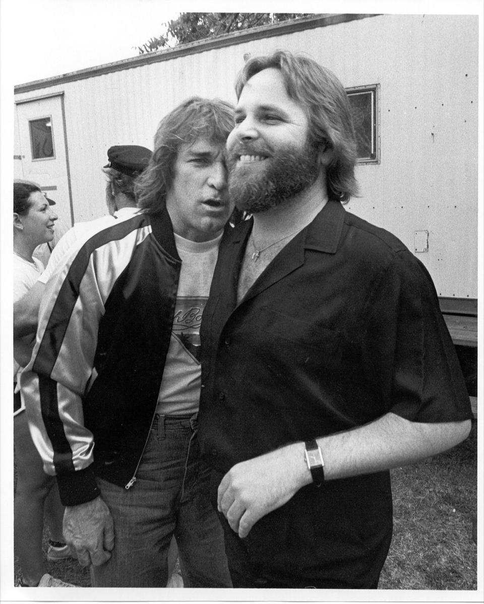 <p>Dennis Wilson and Carl Wilson of The Beach Boys hang out after an outdoor concert in 1975. </p>