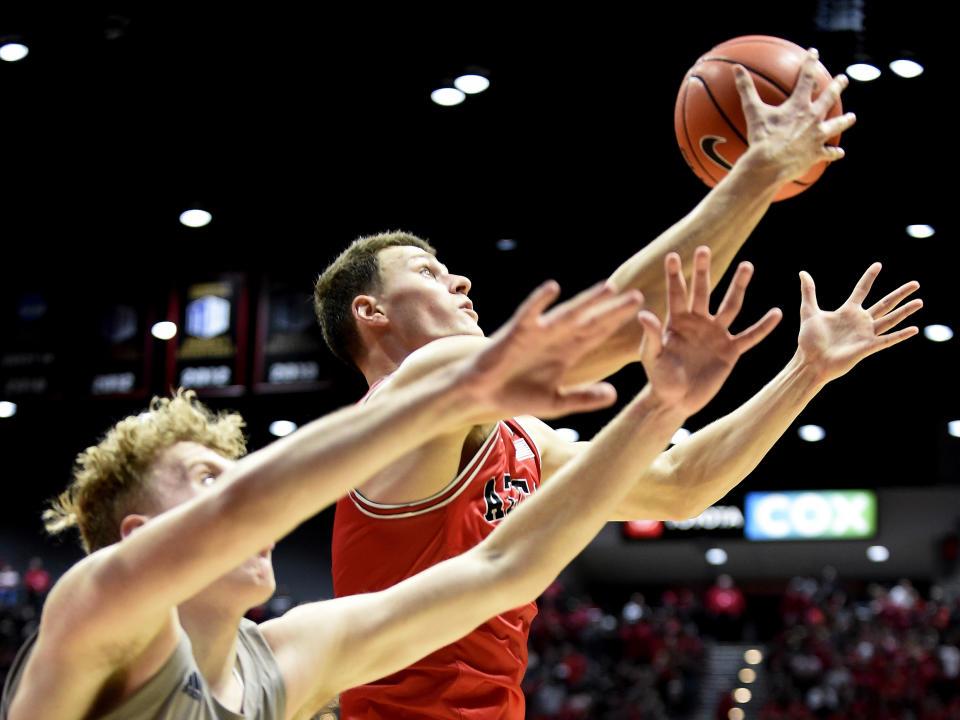 San Diego State forward Yanni Wetzell (5), right, grabs a rebound in front of Nevada forward Zane Meeks (15) during the second half of an NCAA college basketball game Saturday, Jan. 18, 2020, in San Diego. (AP Photo/Denis Poroy)