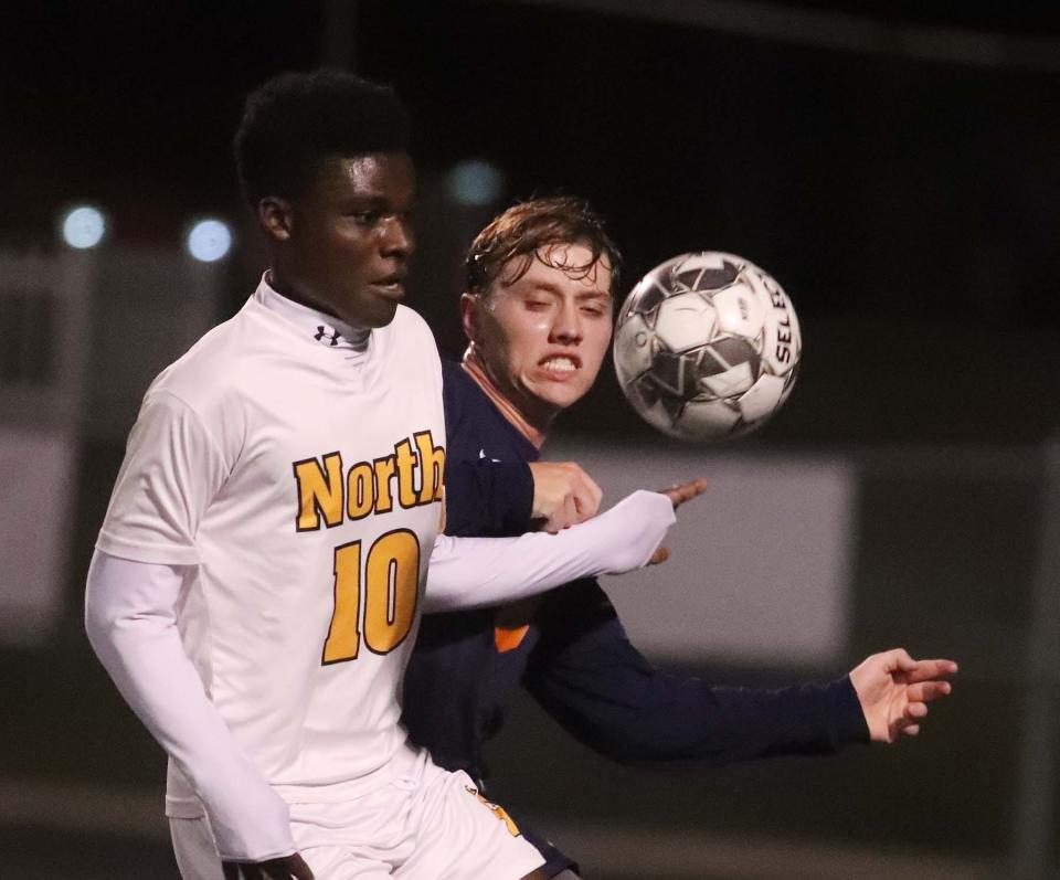 Israel Mandongo, left, of North and Adam Zupancic of Ellet go for the ball during the first half of their game at Ellet High School on Tuesday. 