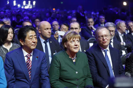 Japanese Prime Minister Shinzo Abe (L-R), German Chancellor Angela Merkel and Stephan Weil Lower Saxony attend the opening ceremony of the CeBit computer fair, which will open its doors to the public on March 20, at the fairground in Hanover, Germany, March 19, 2017. REUTERS/Morris Mac Matzen